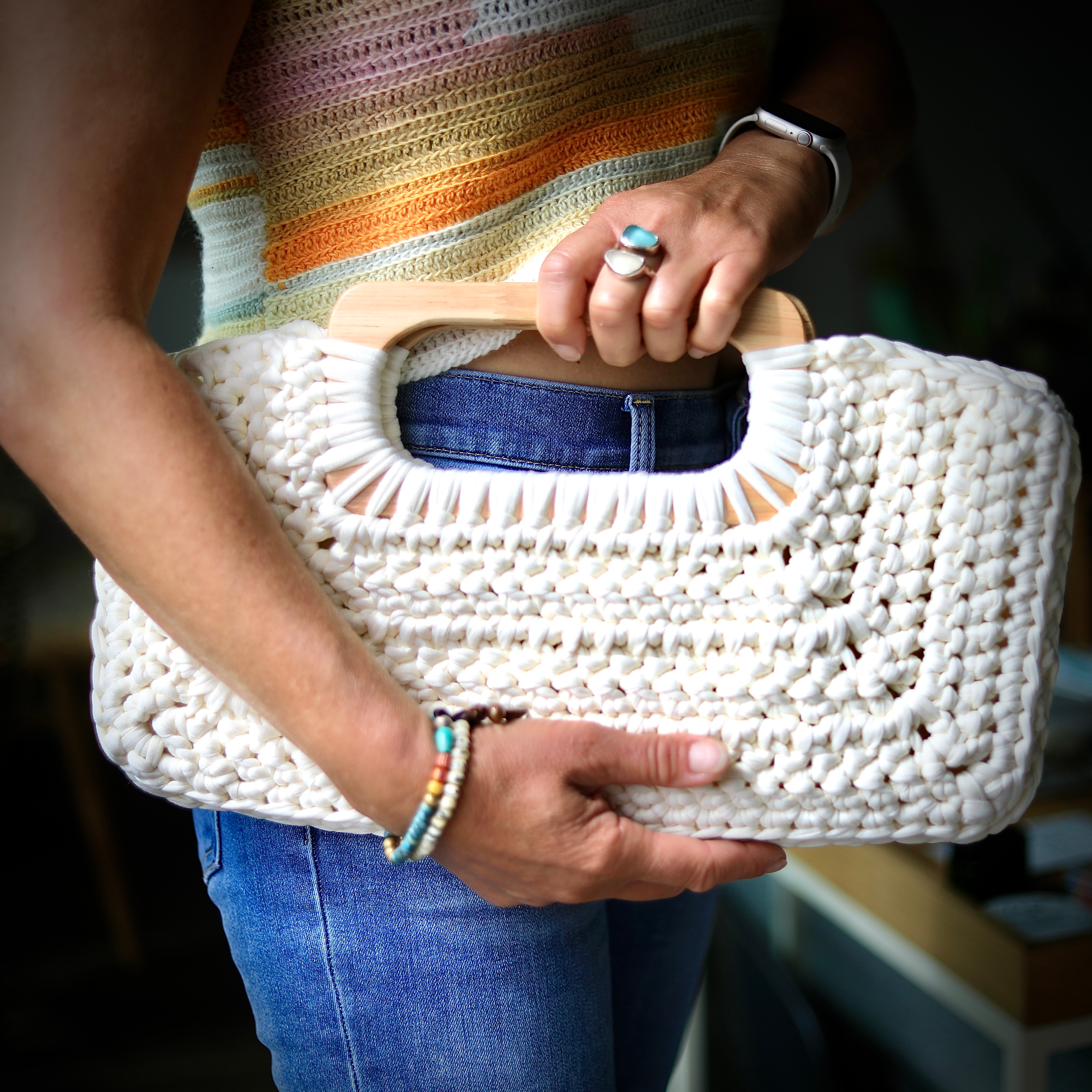 a woman holding a crochet clutch