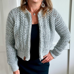 a woman wearing a crochet cardigan with a zipper