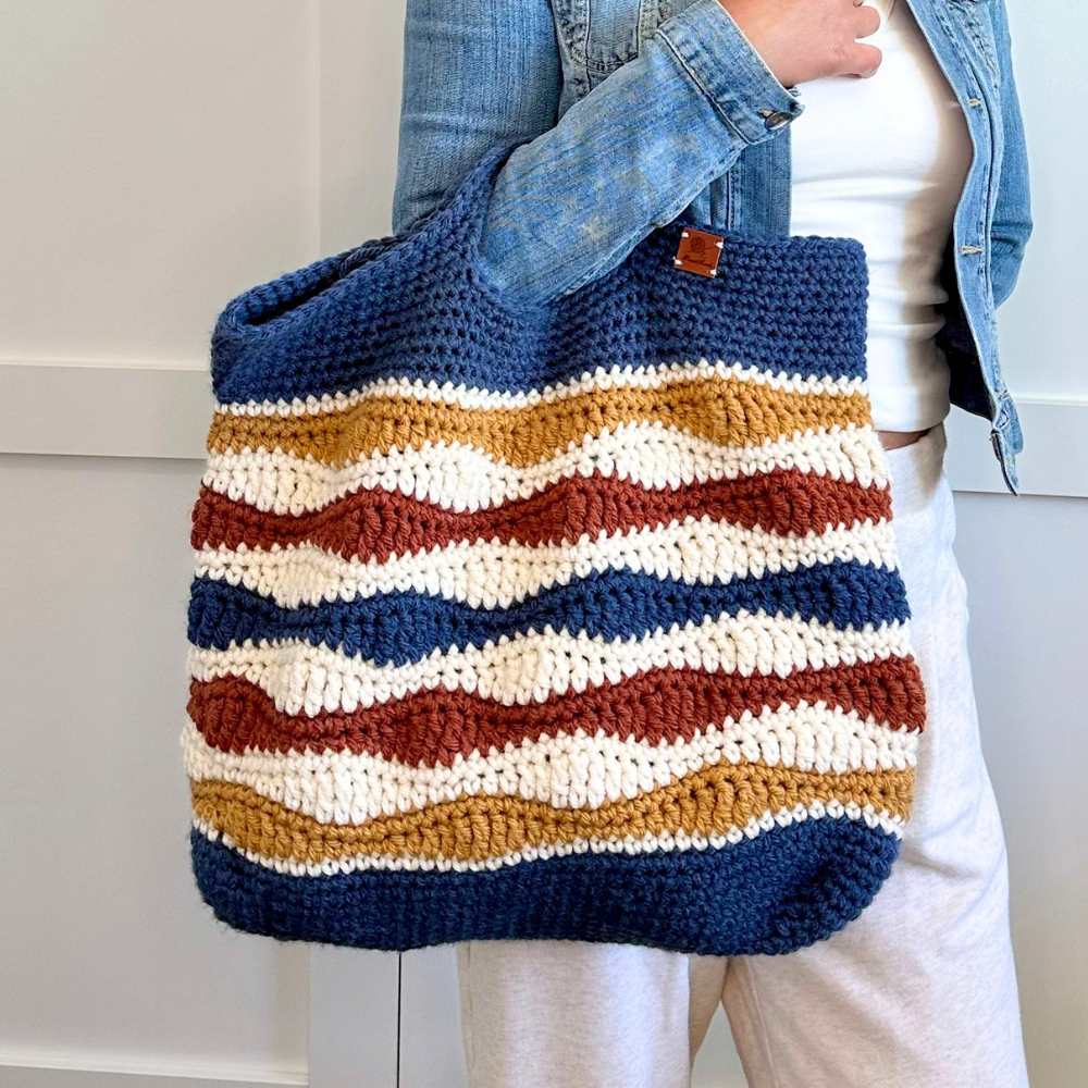 a woman holding a crochet bag