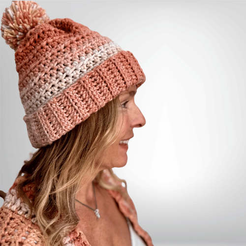 a smiling woman wearing a handmade crochet beanie