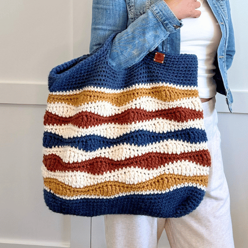 a woman holding a crochet bag