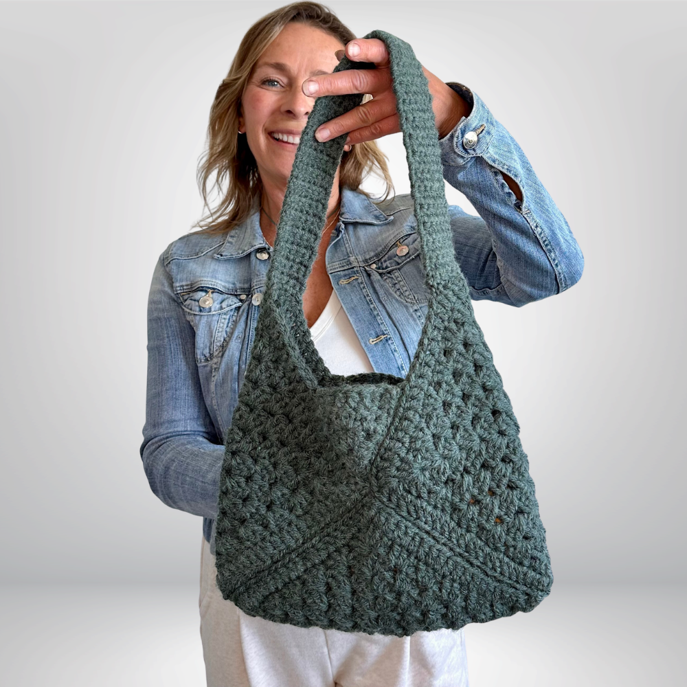 a woman holding a crochet bag