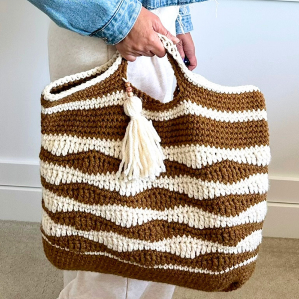a woman holding a crochet bag
