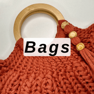 Free crochet bag patterns with a crochet bag with wooden handle laying on a table