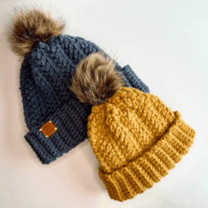 Free crochet hats patterns with 2 beanies laying on a table